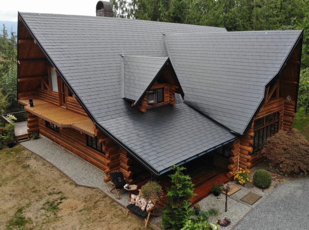 A luxury log cabin featuring a charcoal black standing seam metal roof